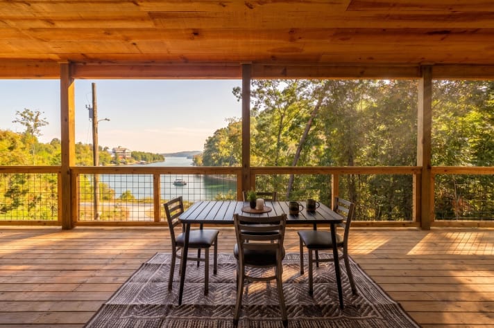 Covered wrap-around porch with outdoor dining and open Douglas Lake views — morning… Douglas Lake, Tennessee Cabin Rental - Gallery Image #4