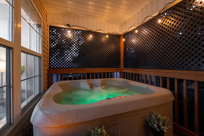 Slip into pure relaxation with a private hot tub glowing under soft string lights.… Pigeon Forge, Tennessee Cabin Rental - Gallery Image #27