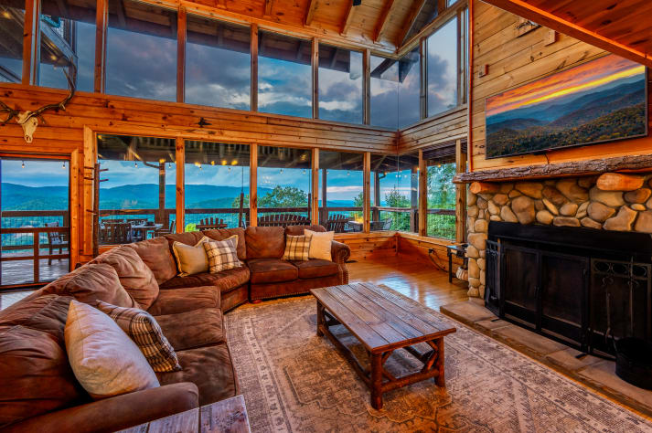 Enjoy stunning views and vaulted ceilings with walls of windows in the cozy living… Sevierville, Tennessee Cabin Rental - Gallery Image #8