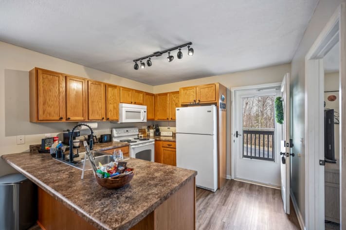 Fully equipped kitchen with modern appliances, ample counter space, and warm wooden… Pigeon Forge, Tennessee Cabin Rental - Gallery Image #13