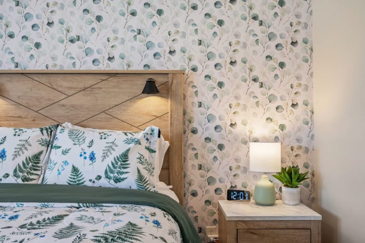 This serene bedroom features cozy botanical bedding, soft lighting, and a stylish… Pigeon Forge, Tennessee Cabin Rental - Gallery Image #19