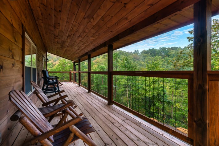Unwind on the covered wraparound deck, rain or shine — the perfect spot to slow… Sevierville, Tennessee Cabin Rental - Gallery Image #34