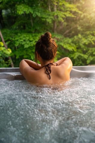 Hot tub at dusk off the master suite — private forest backdrop, heated year-round. Douglas Lake, Tennessee Cabin Rental - Gallery Image #22