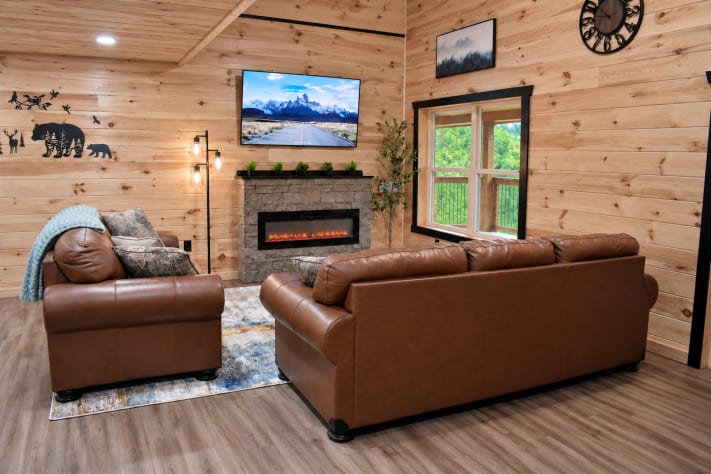 A stone fireplace, Smart TV, and rustic wildlife wall art set the scene in this… Sevierville, Tennessee Cabin Rental - Gallery Image #15