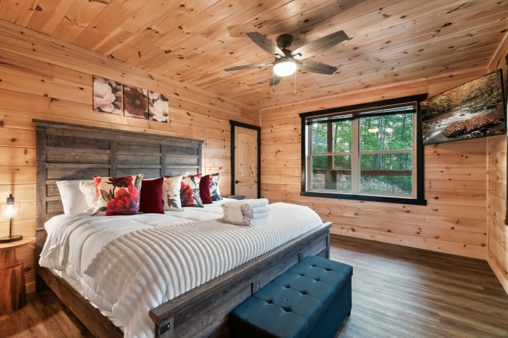 Rest easy in this first-floor king bedroom, styled with a rustic wood headboard… Sevierville, Tennessee Cabin Rental - Gallery Image #5