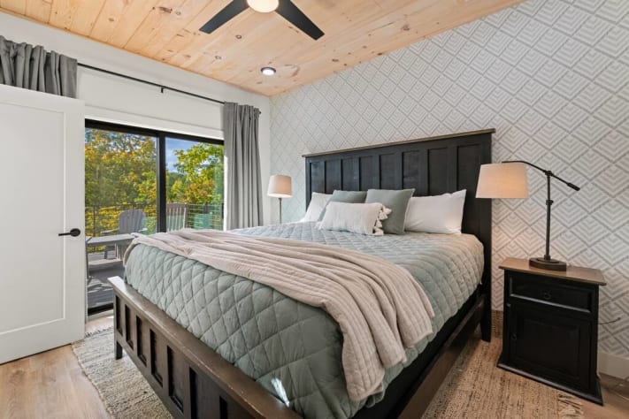 This main level primary suite features a king bed, smart tv, modern attached full… Sevierville, Tennessee Cabin Rental - Gallery Image #15