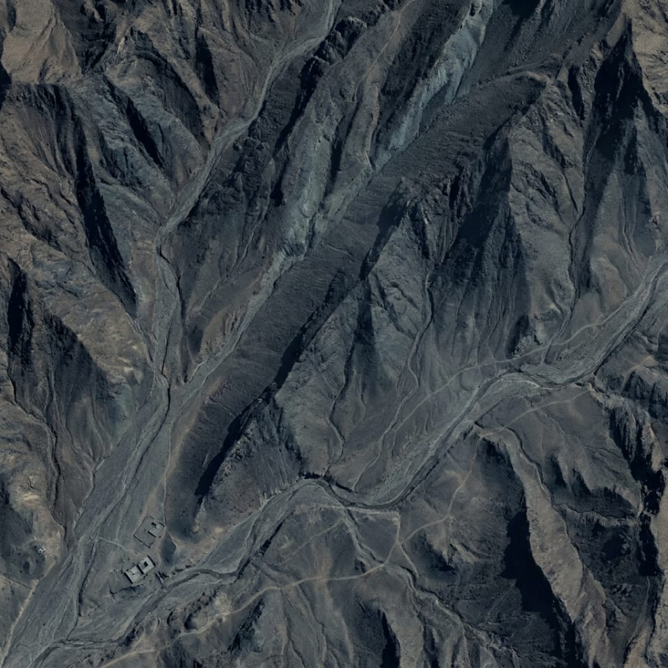 Drone flying over mountain terrain at dusk