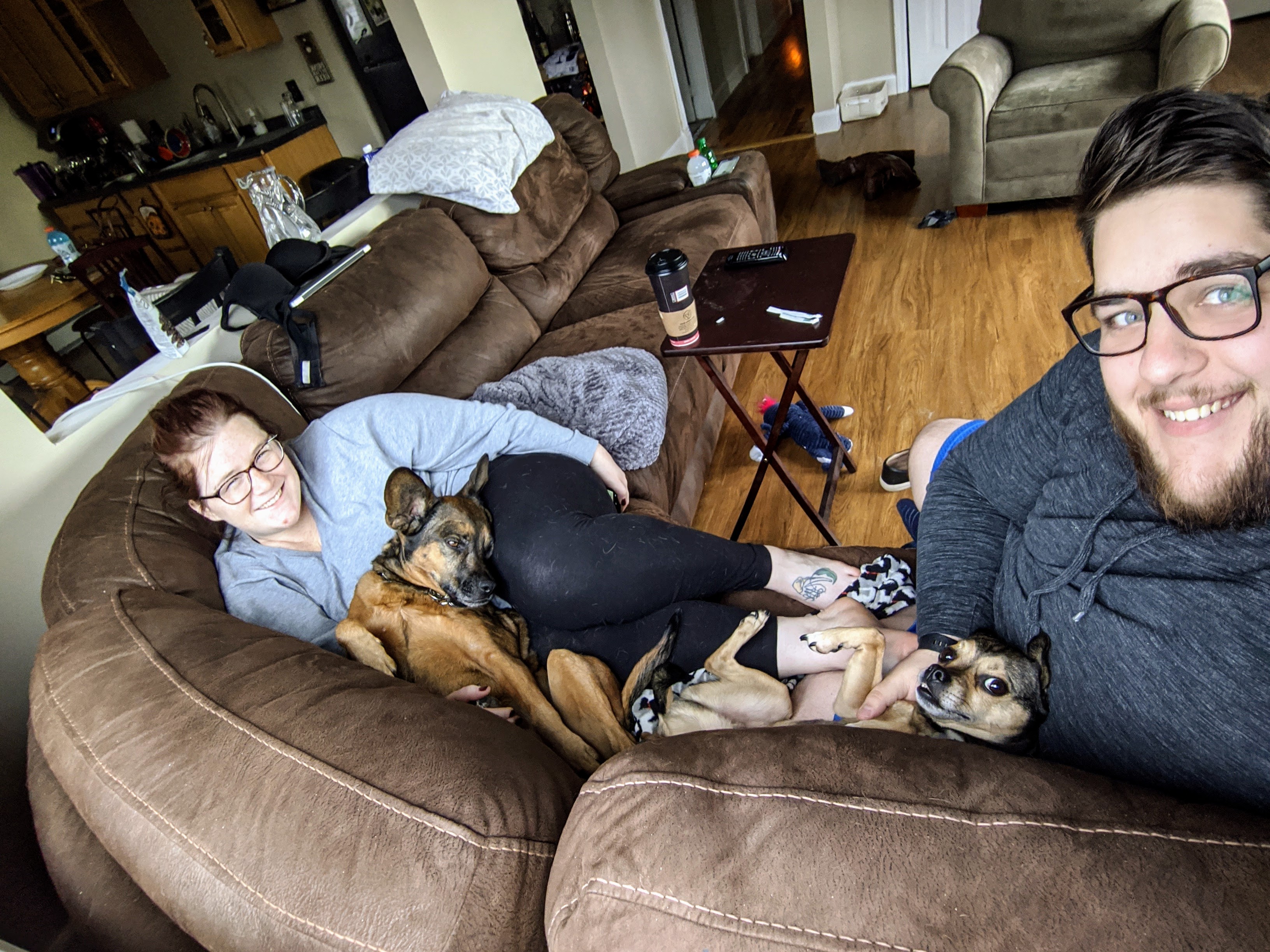 Megan and Ryan on a couch with their dogs, Maggie and Charlie