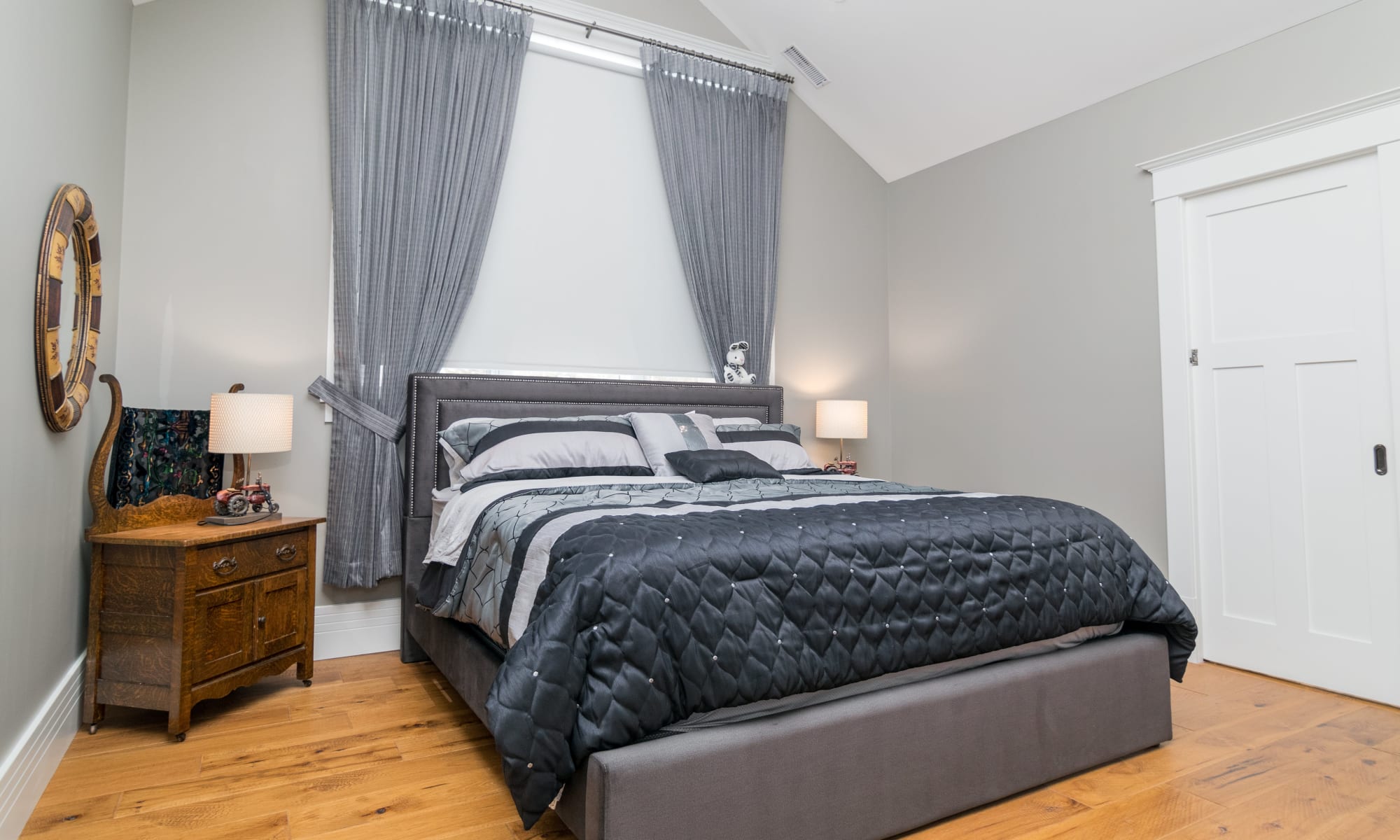 Blackout roller blinds are installed in this great guest bedroom. The light grey textured pattern nicely frames the headboard.
