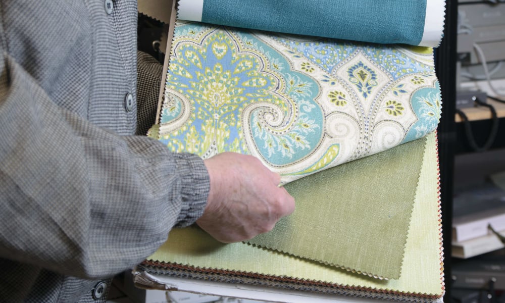 marilyn presenting a fabric sample in her workroom