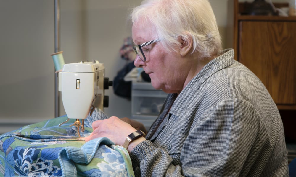 marilyn is putting the final touches on a set of beautiful hand made throw pillows.
