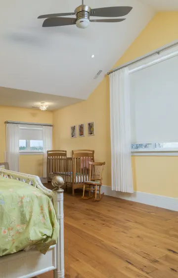 Nursery has blackout blinds, sheers mounted on decorator rods.