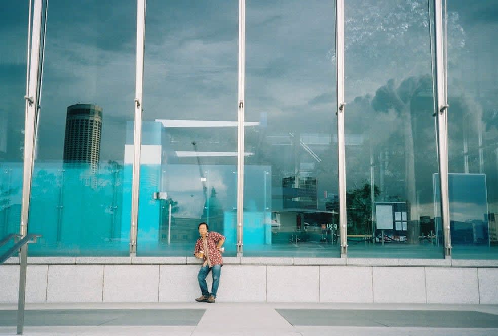 Leaning man at glass wall Singapore downtown