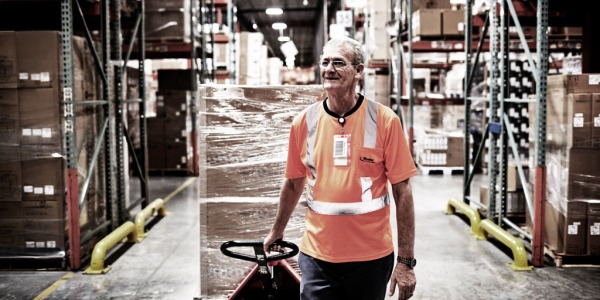 Warehouse Worker Dragging a Pallet behind him