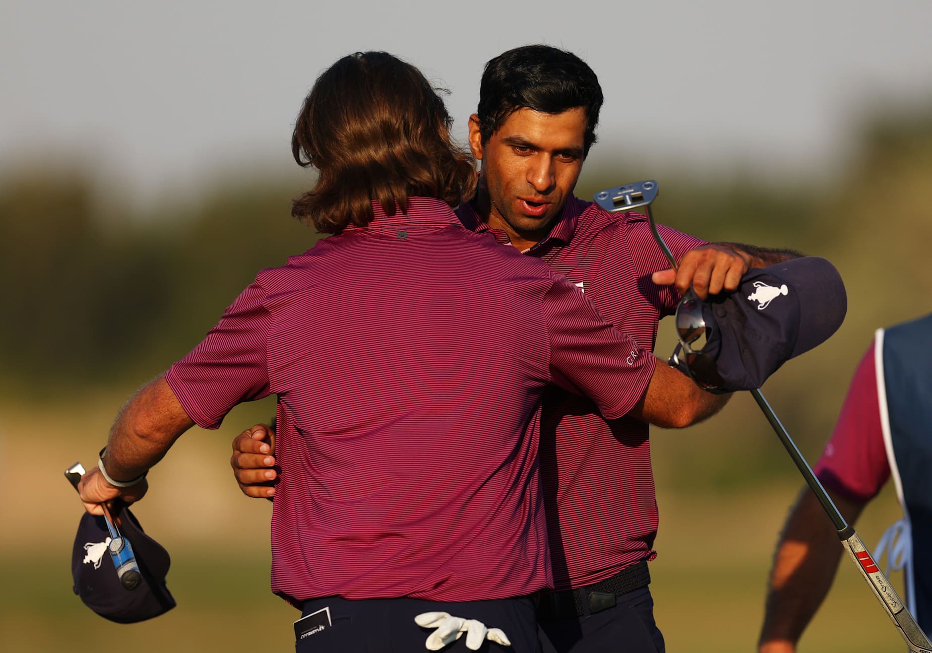 ABU DHABI, UNITED ARAB EMIRATES - JANUARY 10: Aaron Rai and Tommy Fleetwood of Team Great Britain & Ireland embrace on the 16th green during fourballs on day one of the Team Cup at Abu Dhabi Golf Resort on January 10, 2025 in Abu Dhabi, United Arab Emirates. (Photo by Andrew Redington/Getty Images)