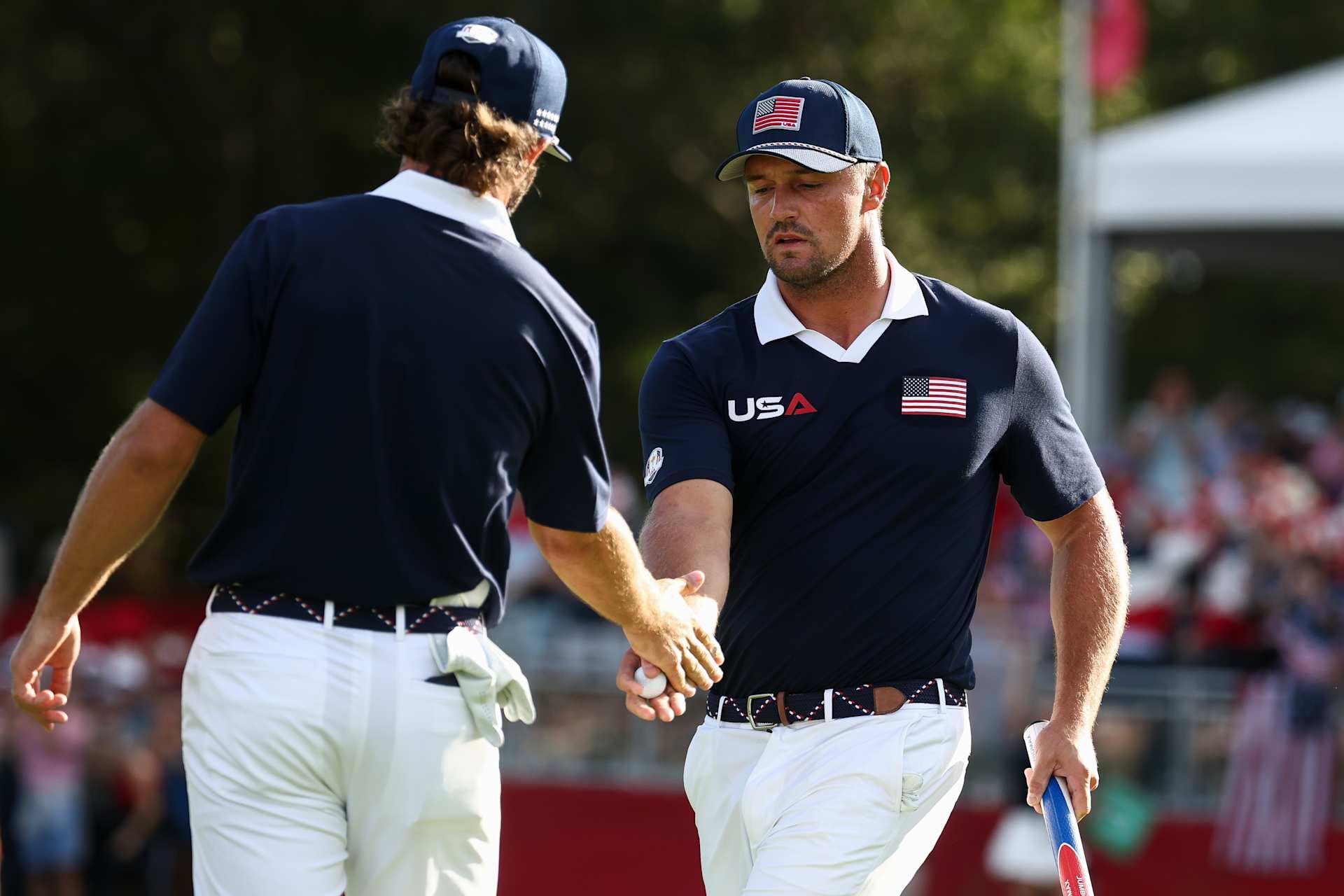 FARMINGDALE, NEW YORK - SEPTEMBER 27: Bryson DeChambeau and Cameron Young of Team United States celebrate on the ninth green during the Saturday morning foursomes matches of the 2025 Ryder Cup at Black Course at Bethpage State Park Golf Course on September 27, 2025 in Farmingdale, New York. (Photo by Jared C. Tilton/Getty Images)