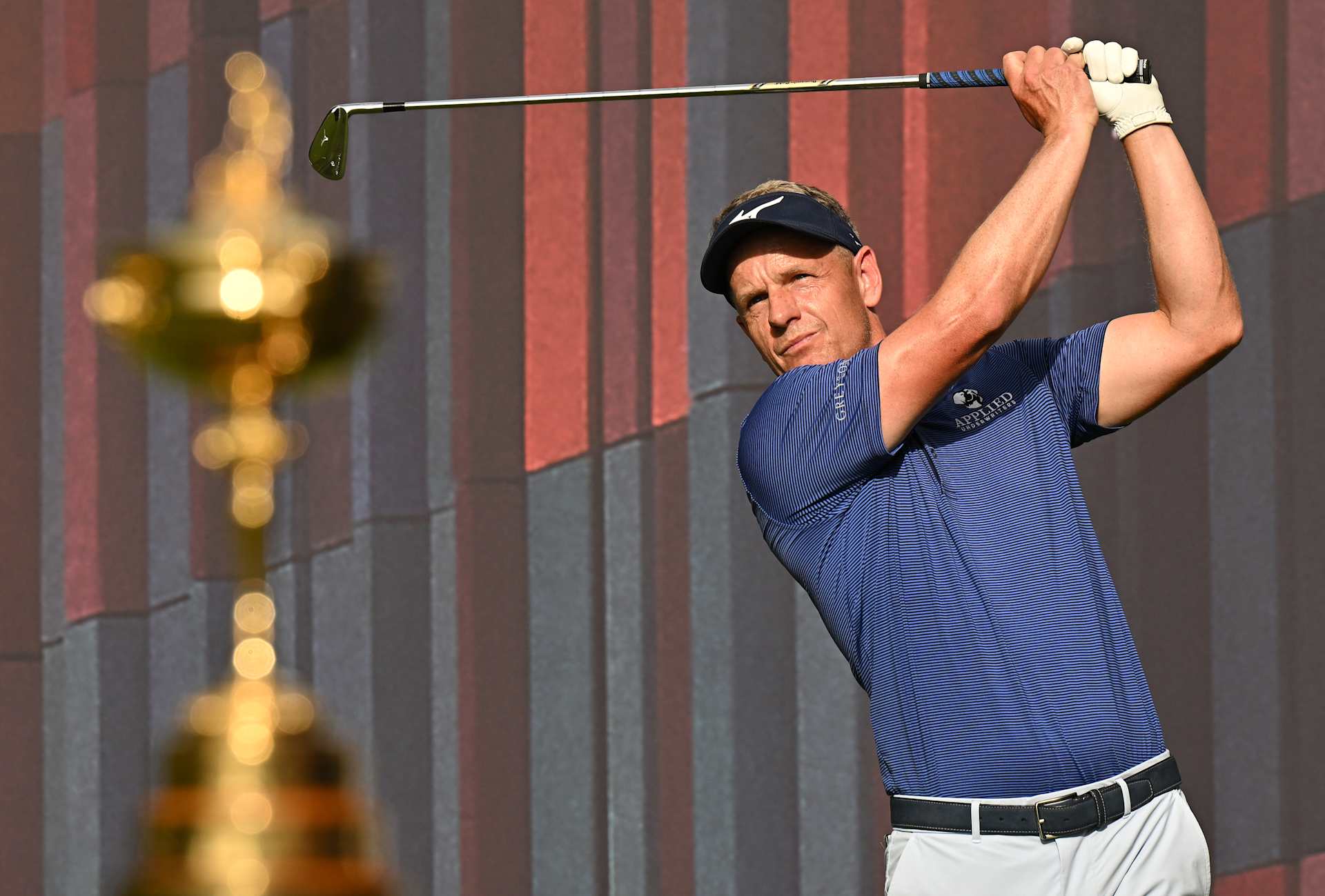 MUNICH, GERMANY - JUNE 21: Ryder Cup Captain Luke Donald of England plays a shot behind the Ryder Cup trophy during the pro-am prior to the BMW International Open at Golfclub Munchen Eichenried on June 21, 2023 in Germany. (Photo by Stuart Franklin/Getty Images)