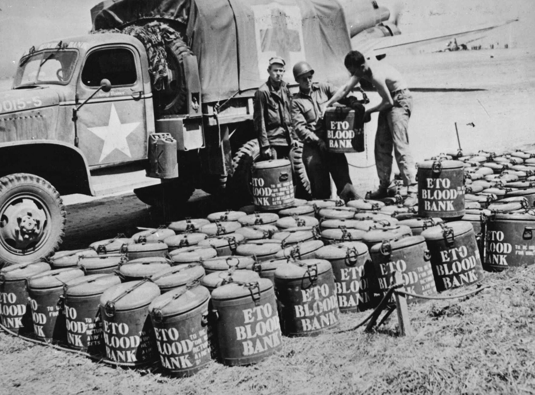 Blood cans, destined for soldiers wounded in Normandy, lined up at an airfield for delivery (1944).