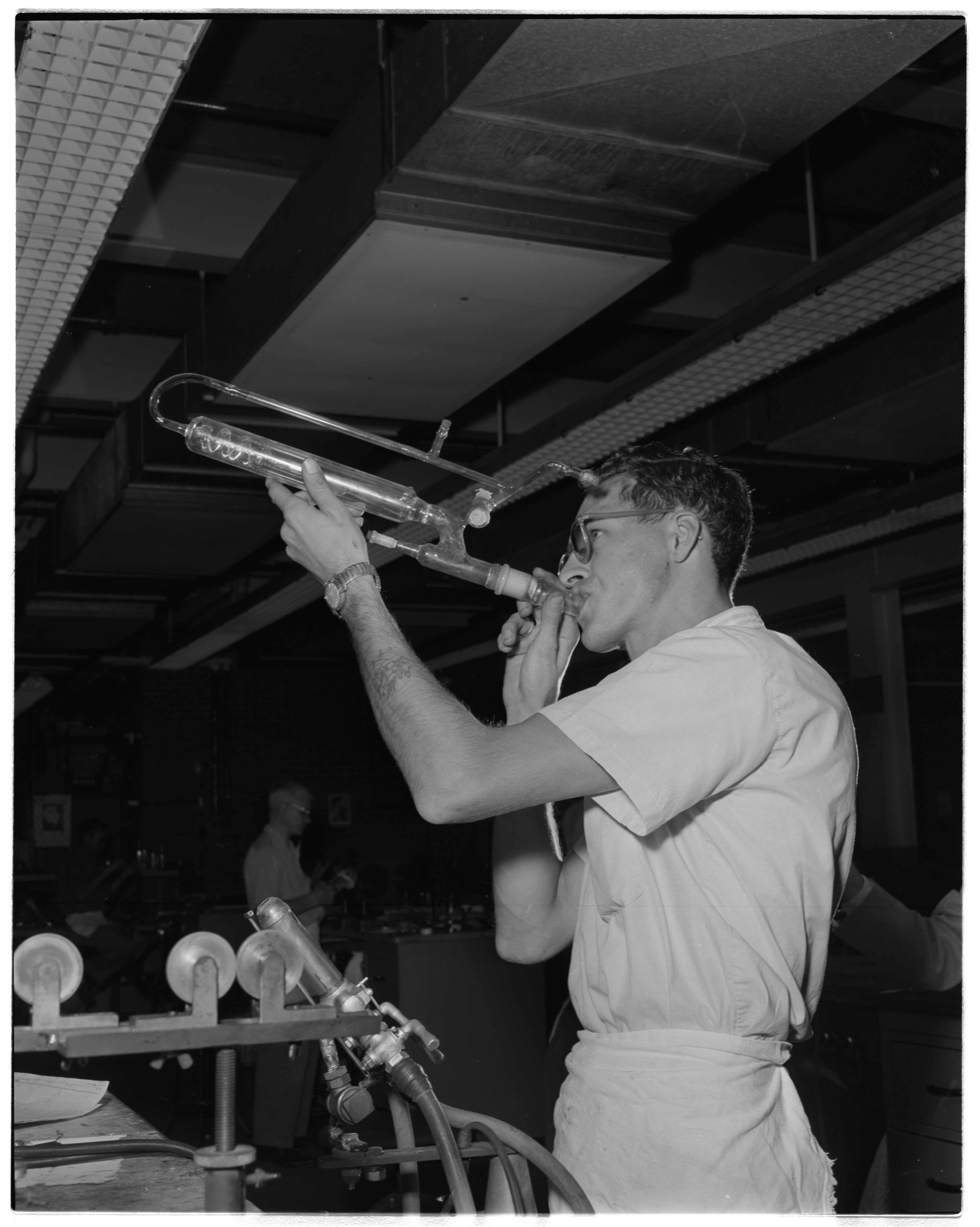A worker blowing glass at the Dow Chemical Company, ca. 1957