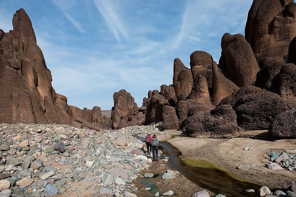 Randonneurs traversant un canyon rocheux du Jbel Siroua