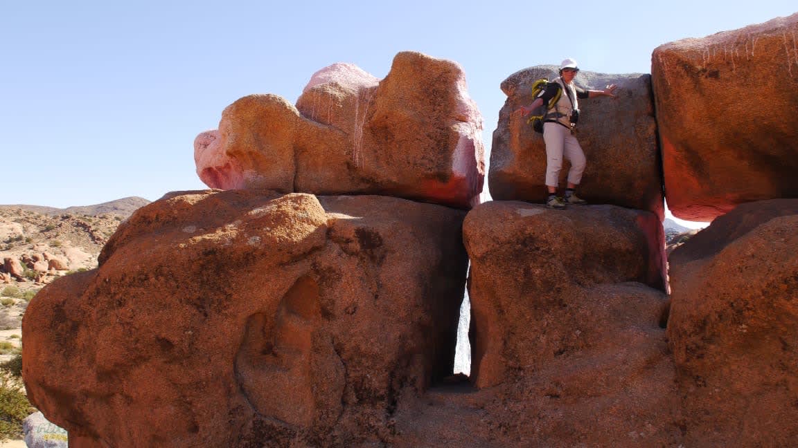Randonneuse parmi les blocs de granit rose de Tafraout dans l’Anti-Atlas