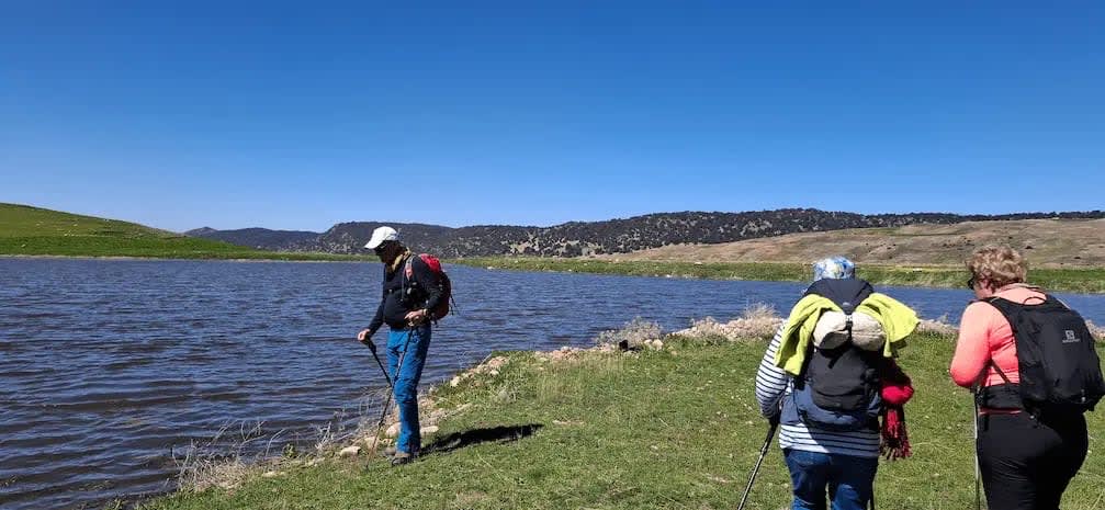 Randonneurs marchant au bord d'un lac d'altitude (aguelmane) dans le Moyen Atlas