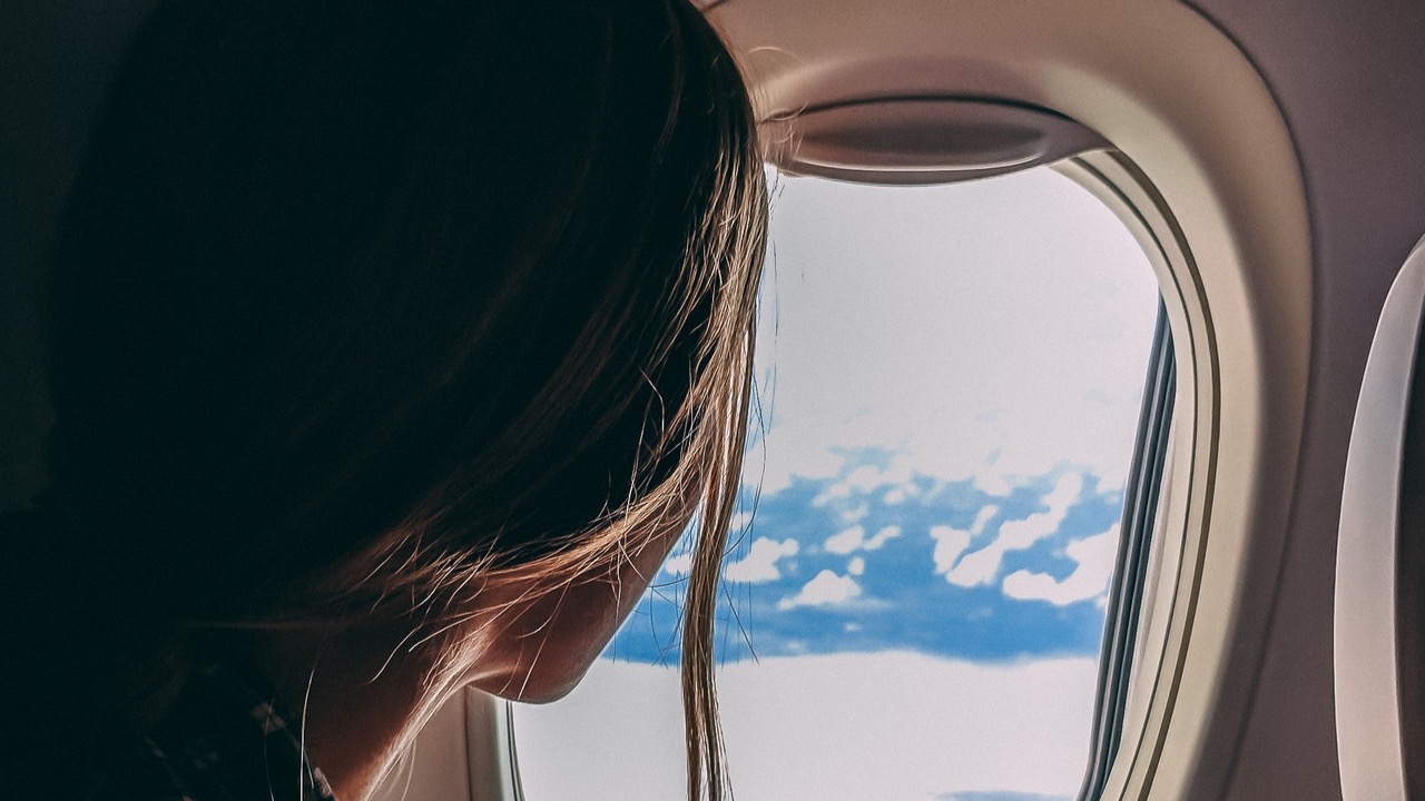 Foto von Jason Toevs: https://www.pexels.com/de-de/foto/person-die-smartphone-reitendes-flugzeug-halt-2033343/