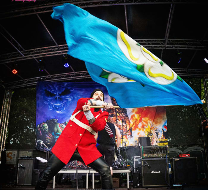 Ey Up Maiden live at Saltaire Festival 2026: Jon Crowder (vocals) in the Trooper redcoat with the Yorkshire flag