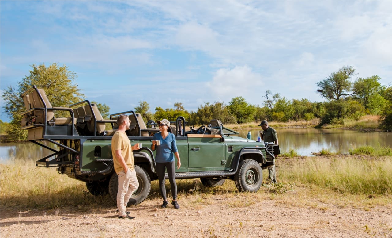 Safari-Urlauber machen Kaffeepause bei der morgendlichen Pirschfahrt