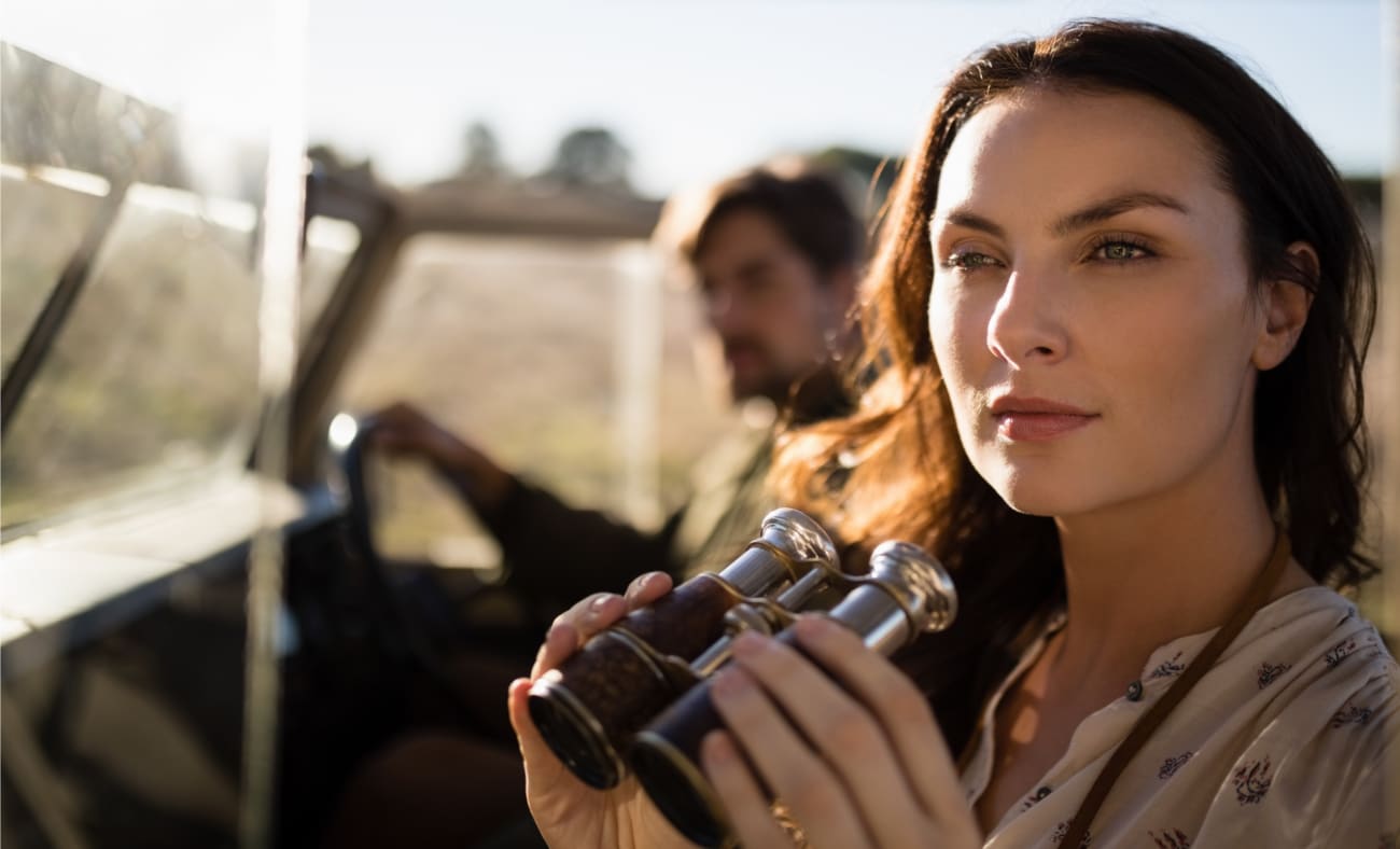 Woman with binoculars on a game drive