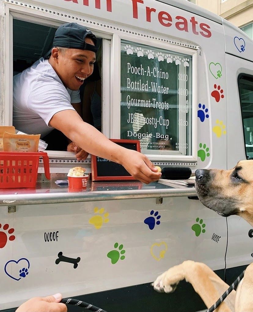 A dog enjoying ice cream made for dogs from an ice cream truck.