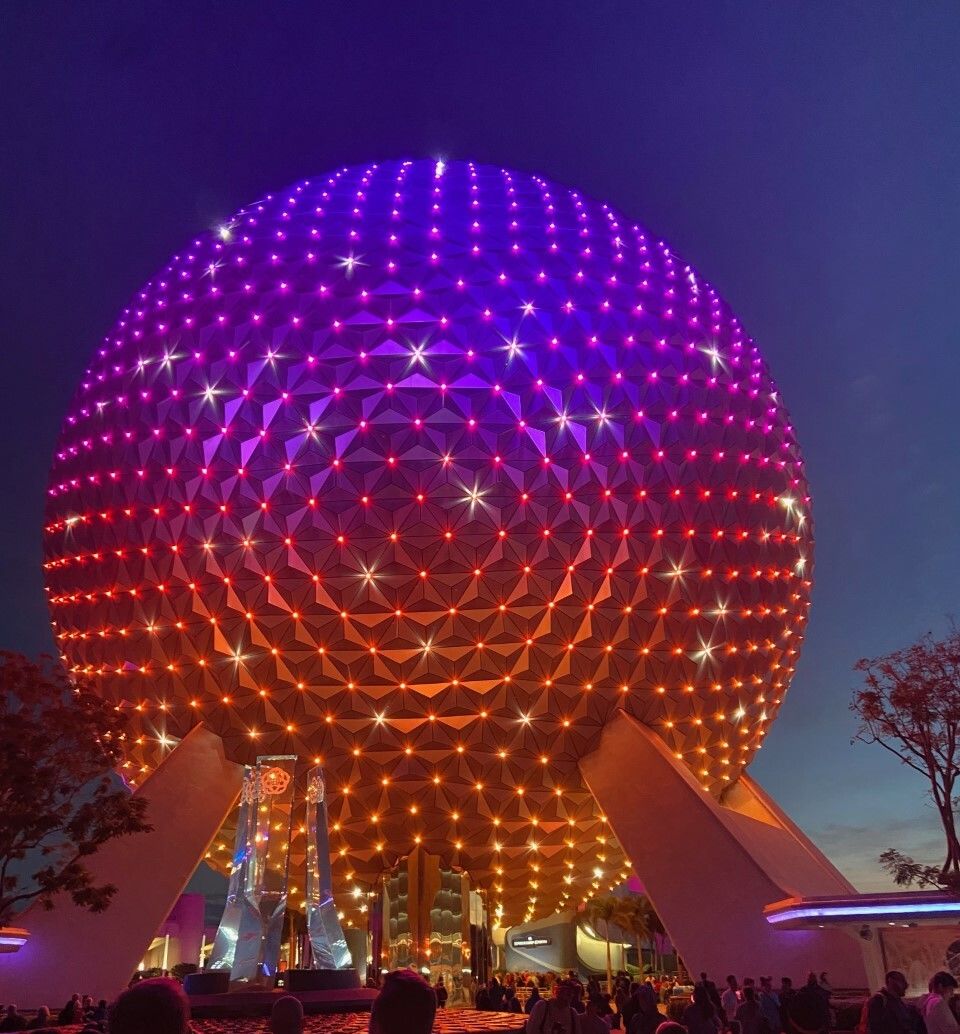 Spaceship Earth lit up at night.