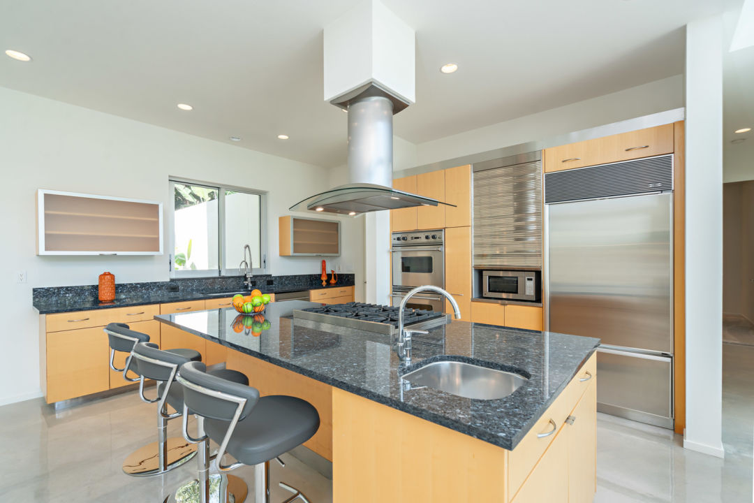 An eat-in kitchen with marble countertops and maplewood cabinetry