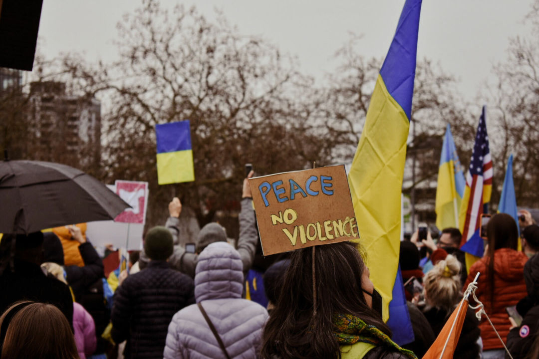 PEACE NO VIOLENCE sign at a rally against the Russian invasion of Ukraine.