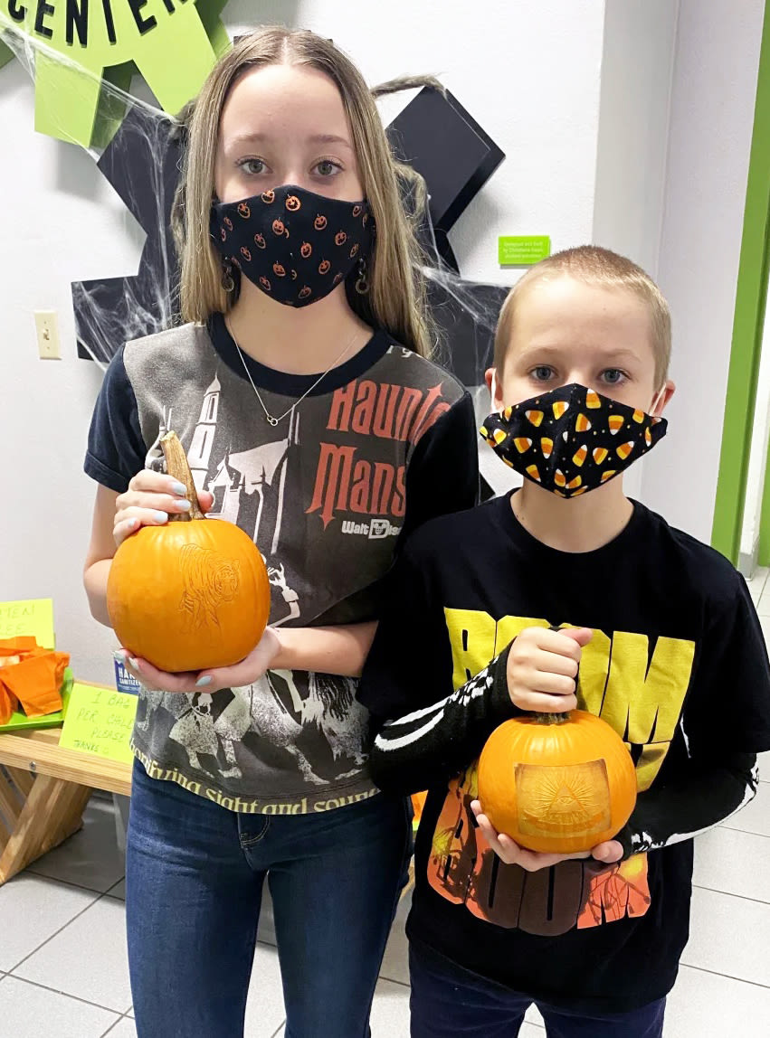 Two Fab Lab-goers get into the Halloween spirit with laser-carved pumpkins.