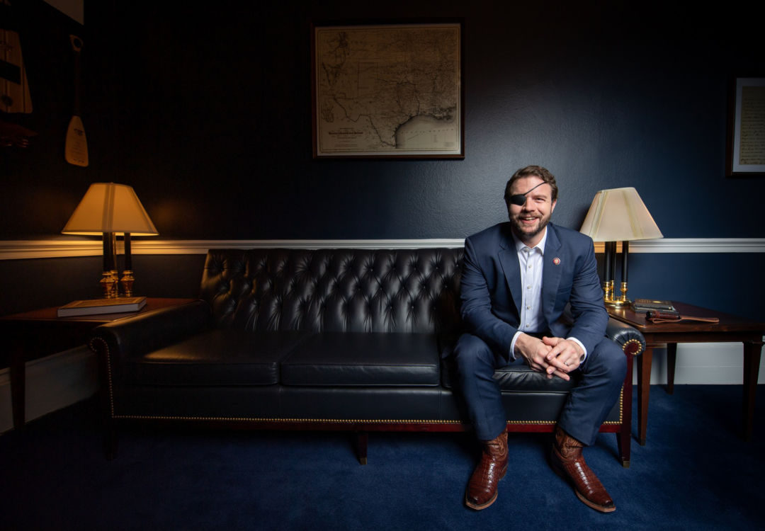U.S. Representative Dan Crenshaw sits on a couch.