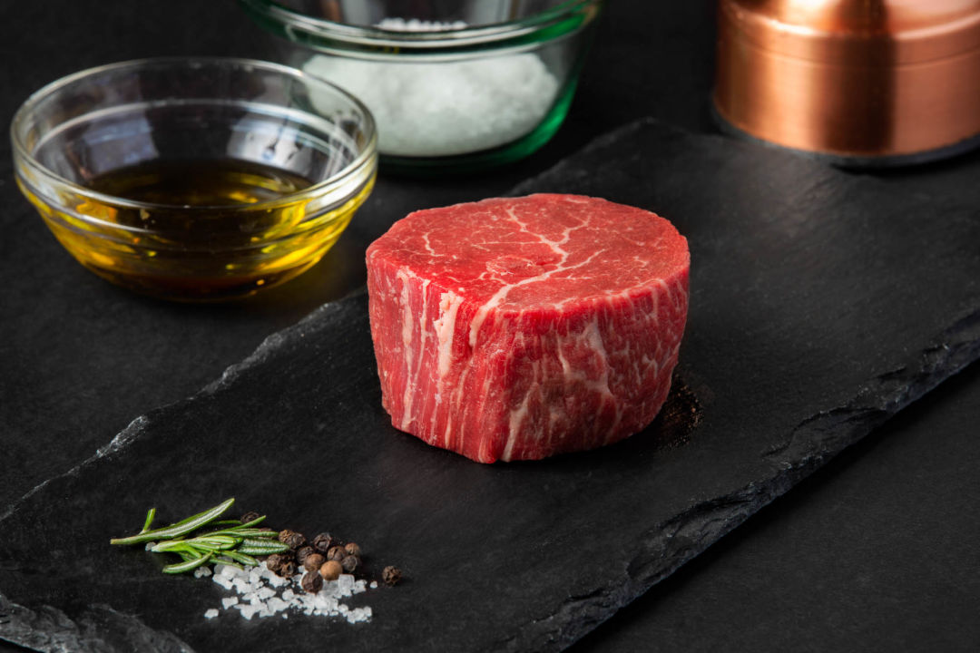 Prime cut of uncooked steak on a slate board