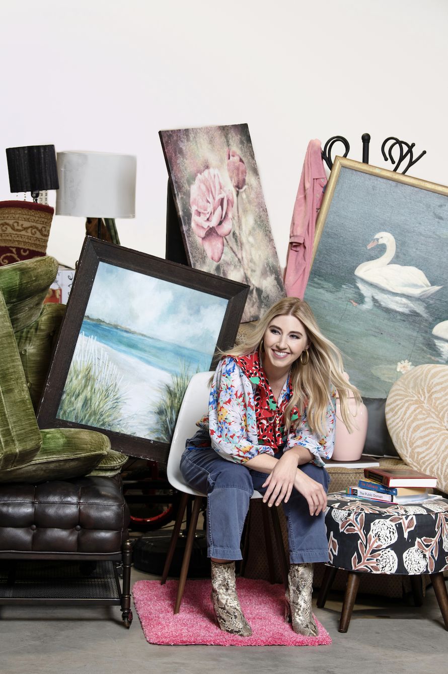 Image of Virginia Chamlee smiling while posing in a chair surrounded by her collection of vintage pieces, decor and furniture.