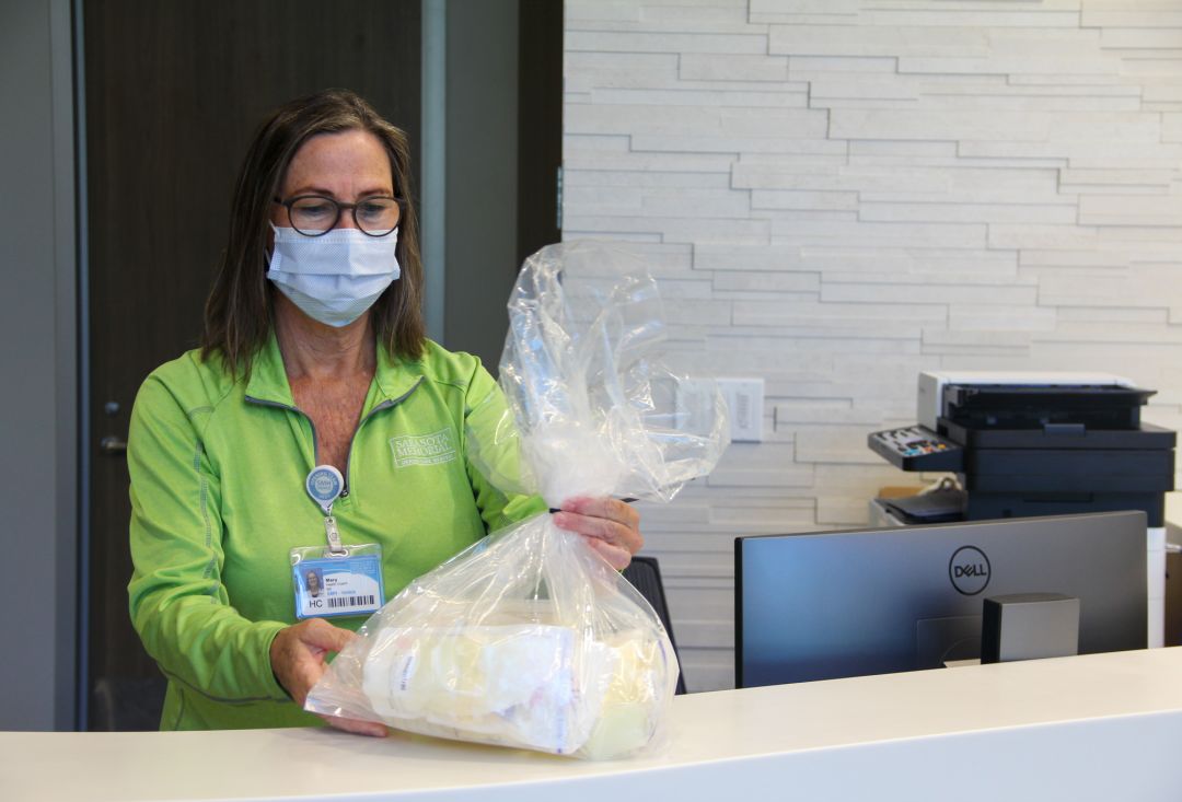 A nurse at SMH-Venice's Milk Depot receives a donation of breast milk.