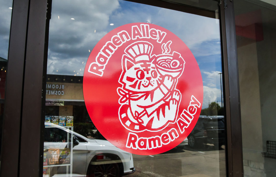 Photo of the Ramen Alley mascot, a ramen-eating cat.