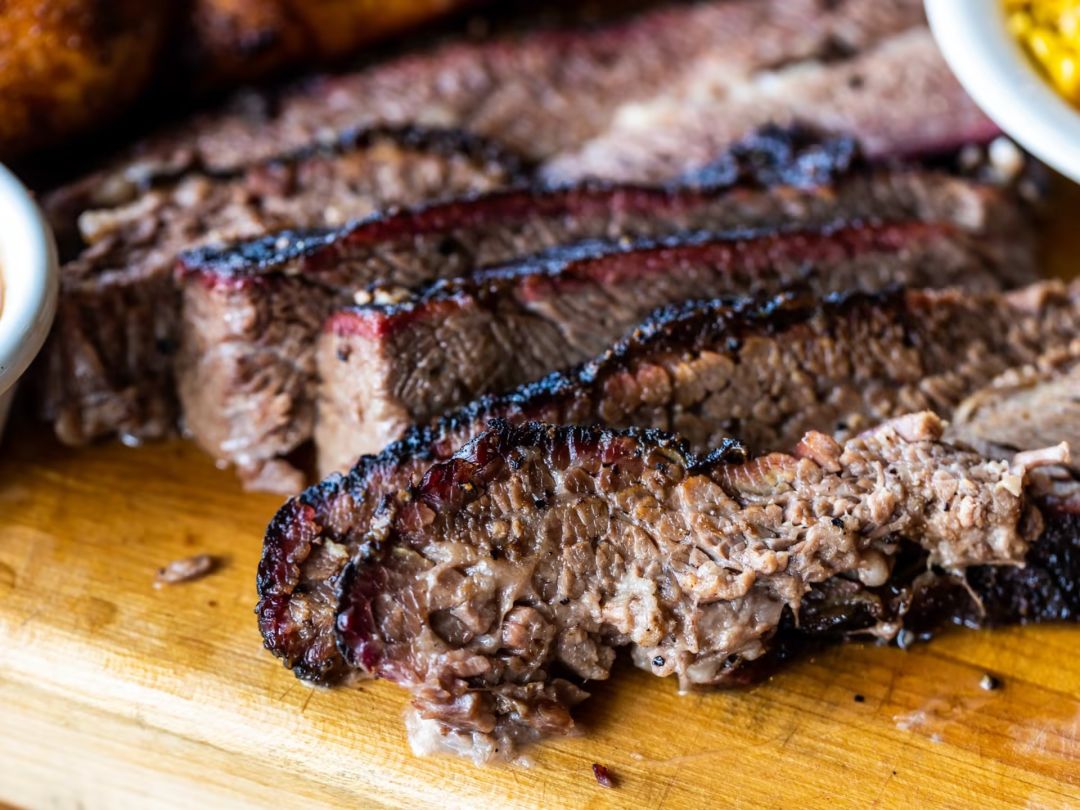 Slices of brisket sit on a cutting board.