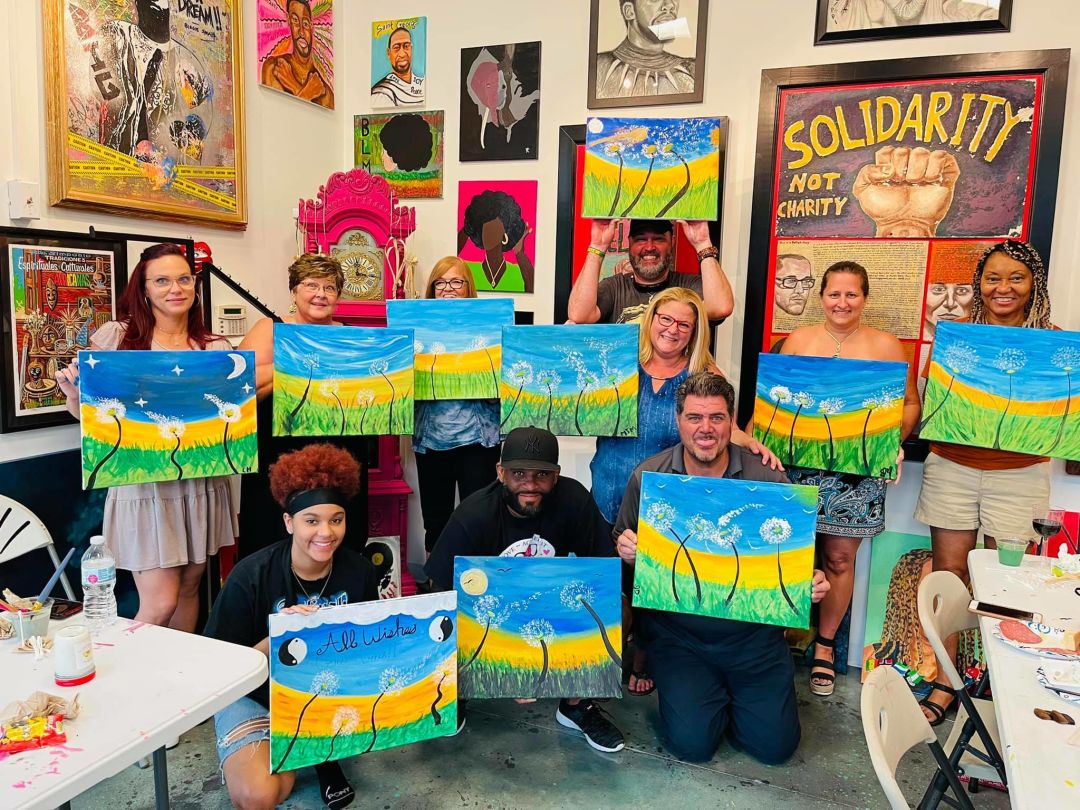 People holding art canvases after an art class.