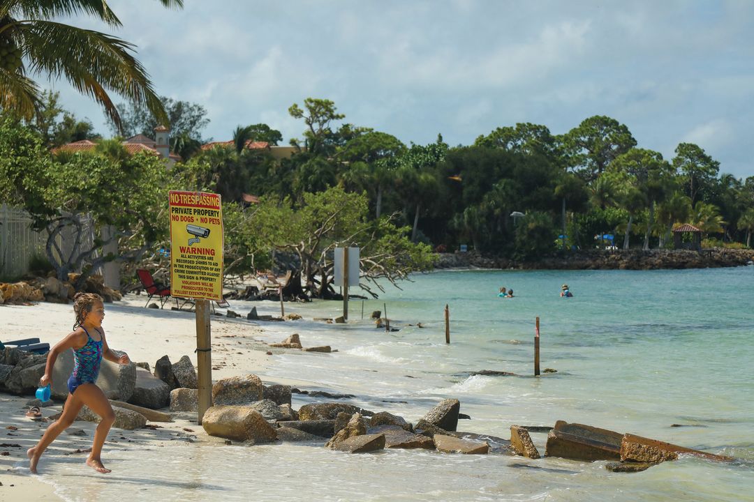 A girl runs beside the “No Tresspassing” sign on Shell Road Beach.