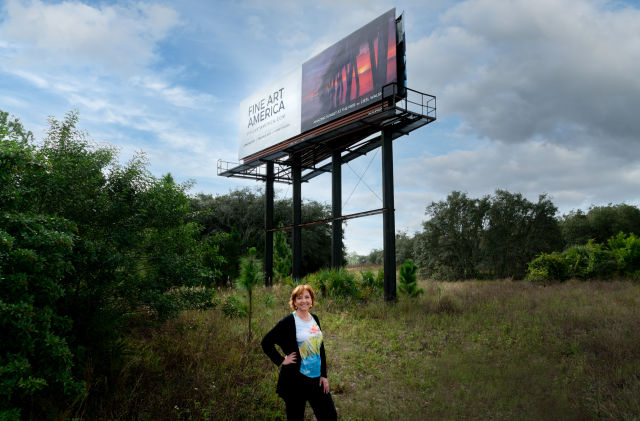 photographer standing in front of billboard of her winning photo