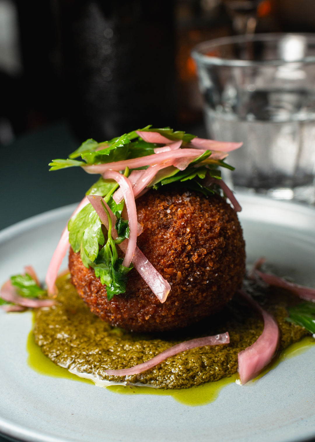 A dirty rice arancini with collard green pistou at Parallel Wine Bar.