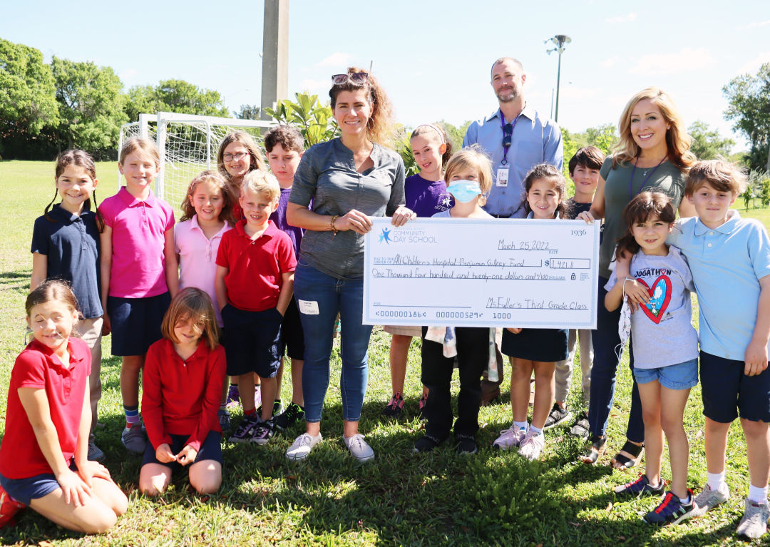 Community Day School’s third-grade students present Laura Gilkey with a check that represents the funds they raised for the Benjamin Gilkey Fund for Innovative Pediatric Cancer Research.