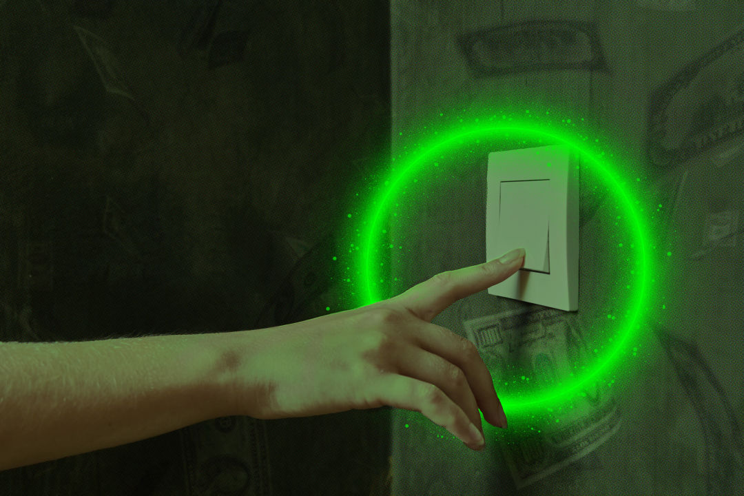 A hand turning off a light switch.