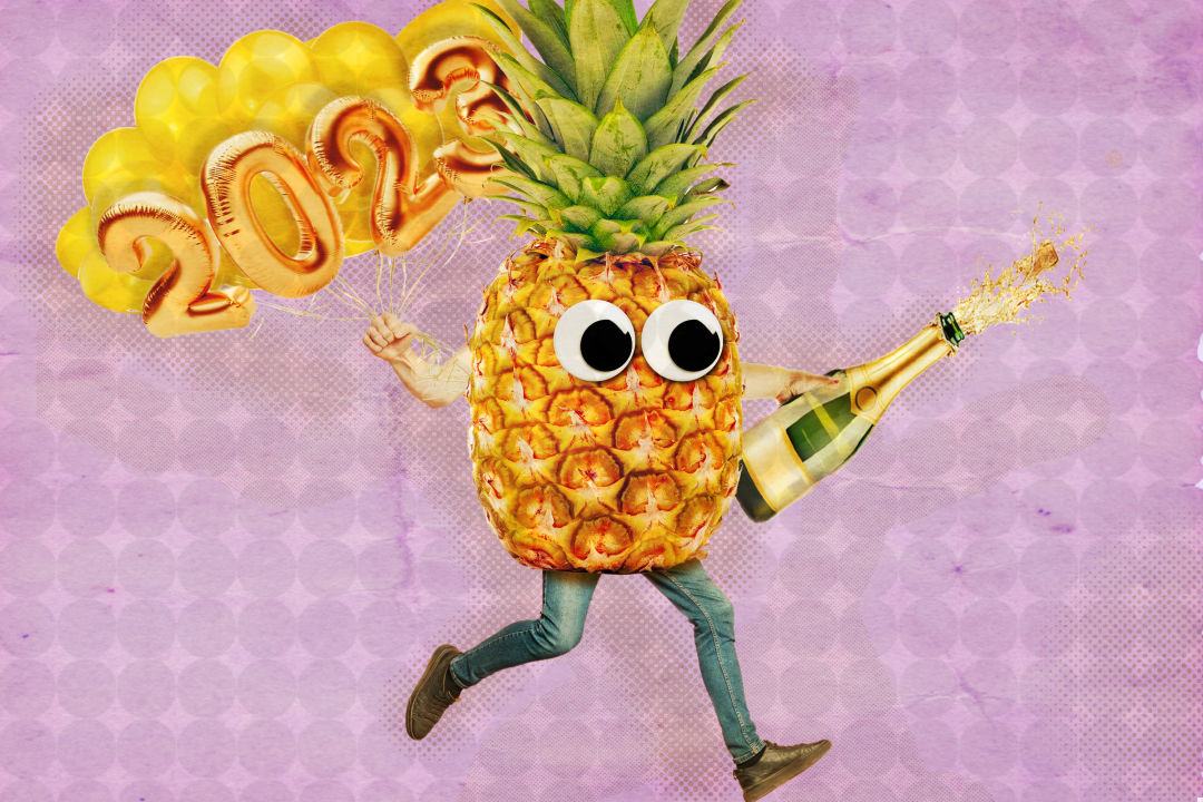Pete the New Year's Pineapple carries 2023 balloons and pops champagne to celebrate the new year.