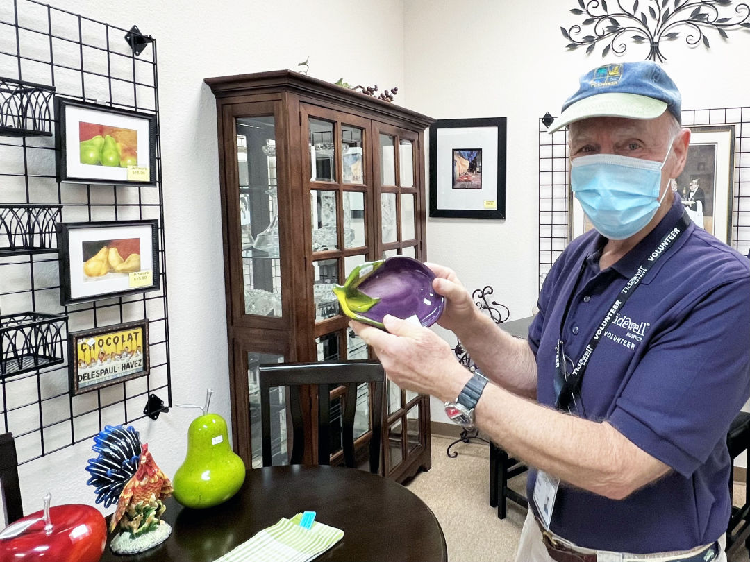 A Tidewell Treasures volunteer shows off items for sale at the new location in Sarasota.