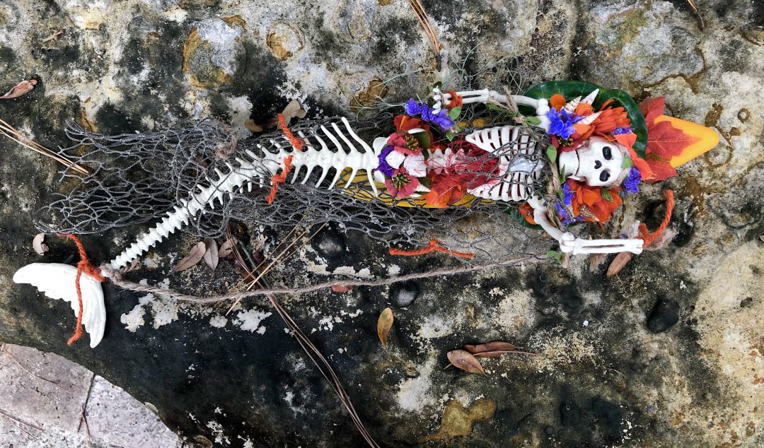 Skeleton mermaid decorated with fake flowers.